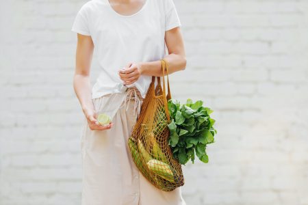 Plastic Free living: model with grocery bag and reusable water bottle
